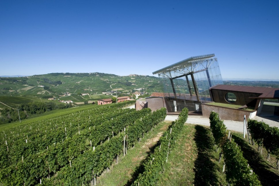 A glass cube structure overlooking vineyards in Italy